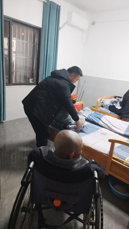 大坪場鎮敬老院院長田松江幫助老人們整理被褥。