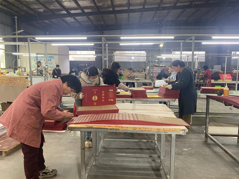 貴州玉山九鼎科技有限公司生產車間內,工人們在生產線上忙碌,加工包裝材料。金莎 攝.jpg