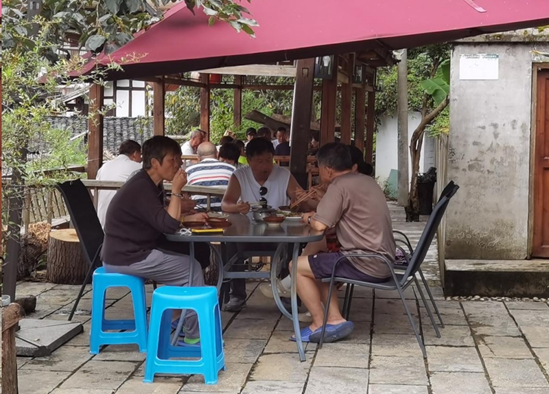 圖為：游客在亭子休息