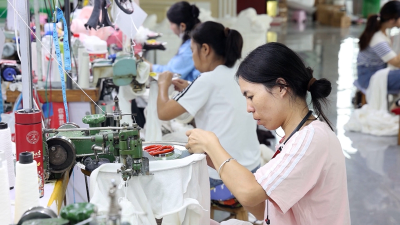 工人們正忙碌的縫制衣服。