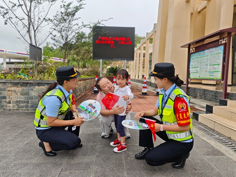 國慶期間，十大隊女子中隊隊員在服務區為司乘人員送上國旗。李玉寧攝