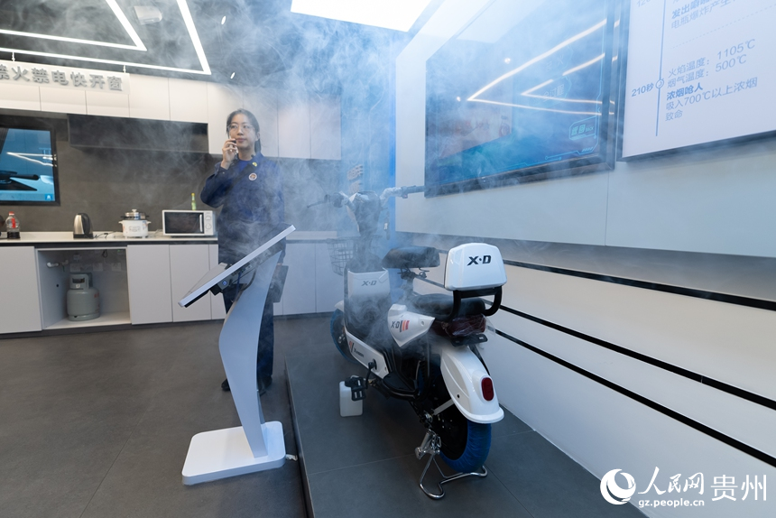 講解員為參觀者演示電動車充電起火燃燒過程。人民網記者 涂敏攝