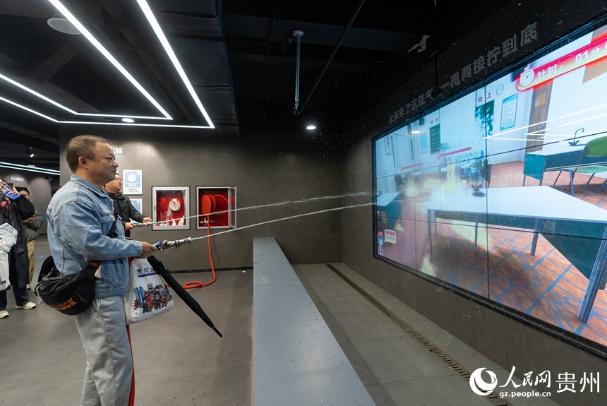 參觀者在科普教育館內體驗消防水槍滅火。人民網記者 涂敏攝